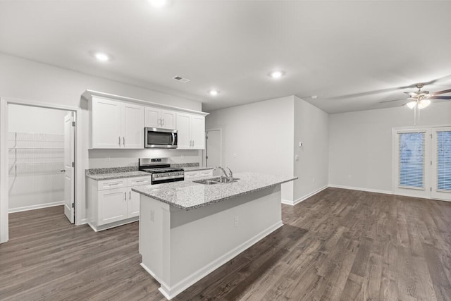 kitchen with sink, white cabinets, dark wood-type flooring, an island with sink, and stainless steel appliances