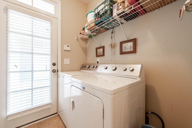 washroom featuring light tile patterned floors, laundry area, and washer and clothes dryer