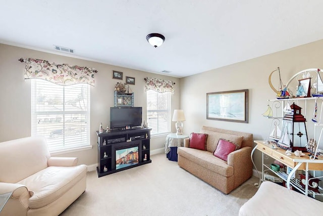 living area featuring light carpet, baseboards, and visible vents