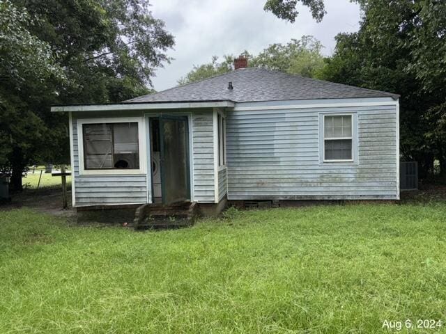 rear view of house featuring a yard