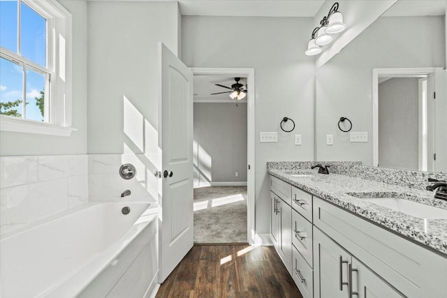 bathroom with ceiling fan, vanity, a washtub, and hardwood / wood-style flooring