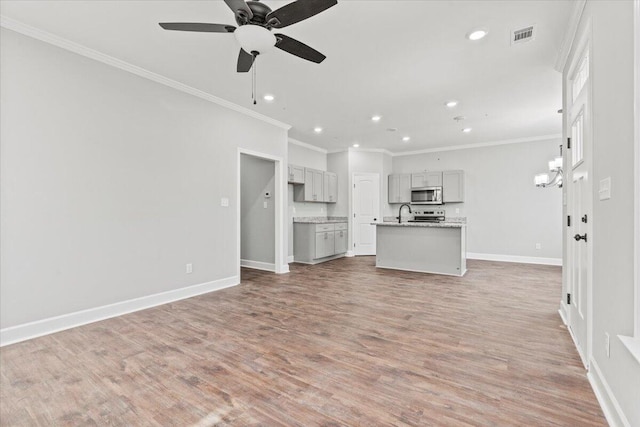 unfurnished living room with light wood-type flooring, ceiling fan, and crown molding