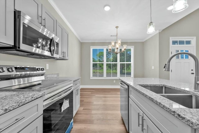 kitchen featuring stainless steel appliances, a sink, a notable chandelier, and crown molding