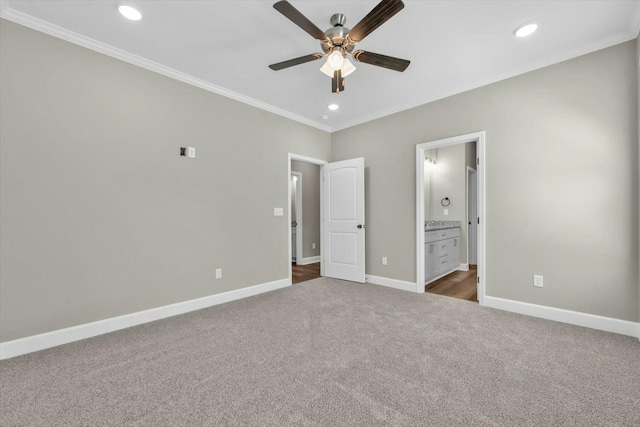 unfurnished bedroom featuring crown molding, carpet, baseboards, ensuite bath, and recessed lighting