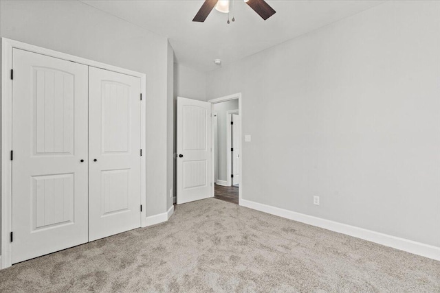 unfurnished bedroom featuring ceiling fan, light colored carpet, and a closet