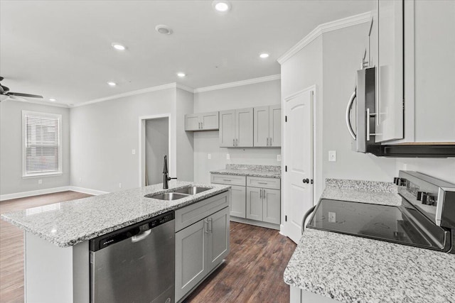 kitchen with dark wood-type flooring, sink, appliances with stainless steel finishes, and a kitchen island with sink