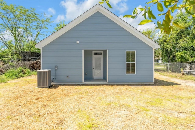rear view of property with fence and central AC