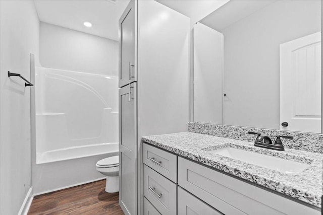 full bathroom featuring shower / bathtub combination, hardwood / wood-style floors, toilet, and vanity