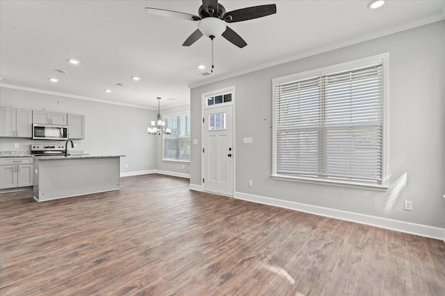 unfurnished living room with crown molding, dark hardwood / wood-style floors, and ceiling fan with notable chandelier