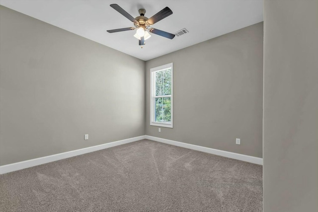 carpeted empty room featuring visible vents, baseboards, and ceiling fan