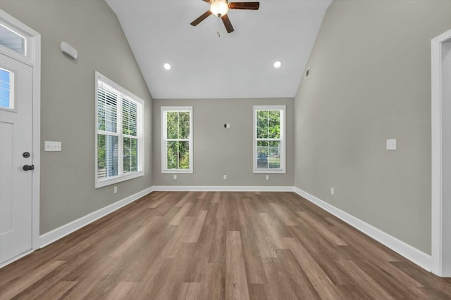 unfurnished living room with ceiling fan, lofted ceiling, wood finished floors, and baseboards