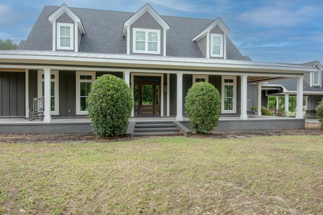 rear view of house featuring a yard and a porch