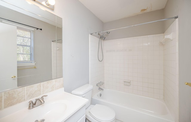 full bathroom featuring tiled shower / bath combo, vanity, and toilet