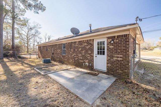 rear view of house with central air condition unit and a patio