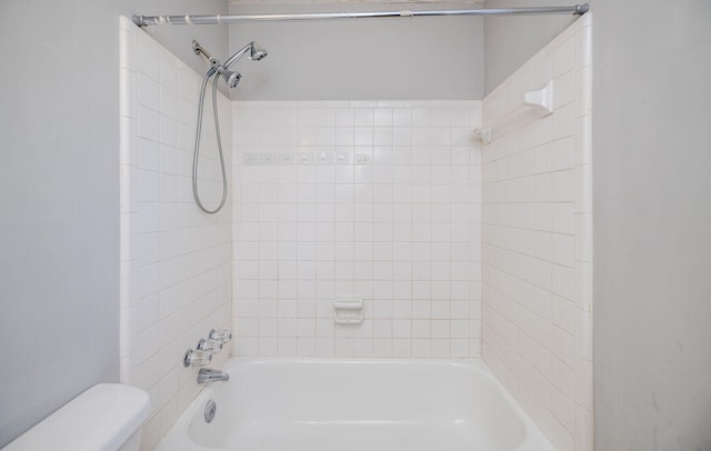 bathroom featuring toilet and tiled shower / bath