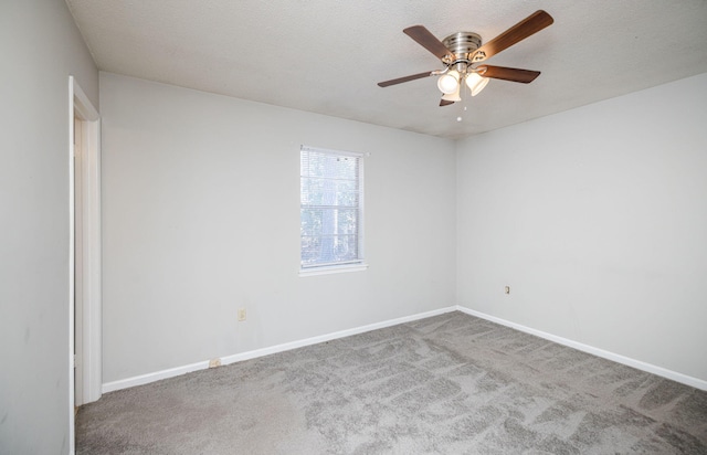 carpeted empty room with ceiling fan and a textured ceiling