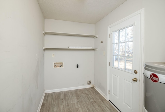 laundry area featuring water heater, washer hookup, a textured ceiling, and light wood-type flooring