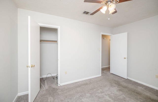 unfurnished bedroom featuring light carpet, ceiling fan, and a closet