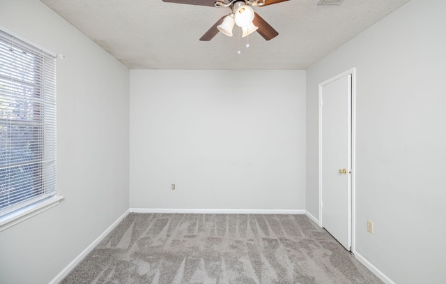 carpeted spare room featuring a textured ceiling and ceiling fan