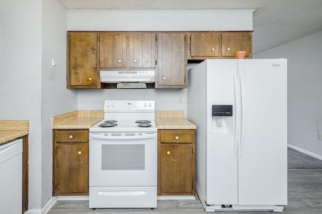 kitchen with white appliances, light hardwood / wood-style flooring, and a textured ceiling