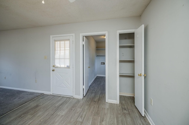 interior space with a textured ceiling and light wood-type flooring