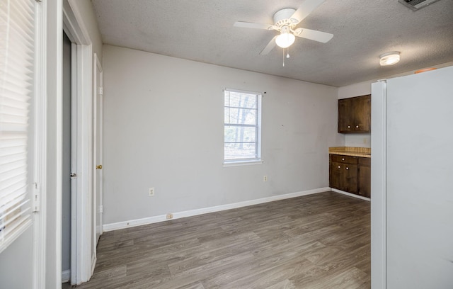 interior space featuring ceiling fan, hardwood / wood-style floors, and a textured ceiling