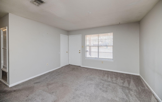 carpeted empty room with a textured ceiling