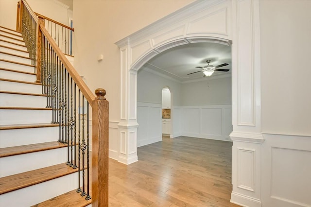 interior space with crown molding, ceiling fan, hardwood / wood-style floors, and ornate columns