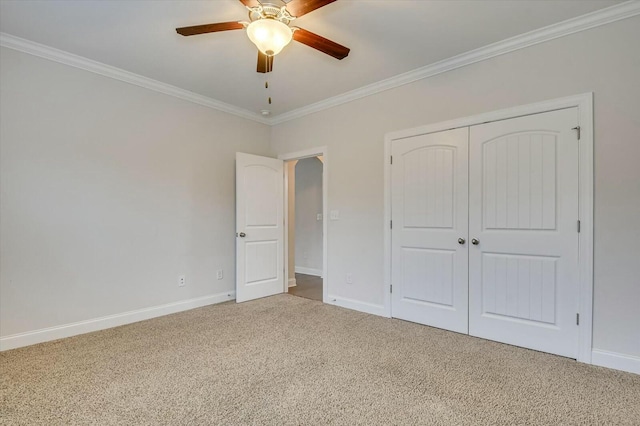 unfurnished bedroom with ornamental molding, carpet, ceiling fan, and a closet