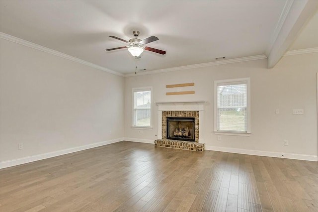 unfurnished living room with hardwood / wood-style floors, crown molding, a brick fireplace, and ceiling fan