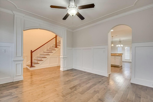 empty room with ceiling fan, ornamental molding, and light wood-type flooring