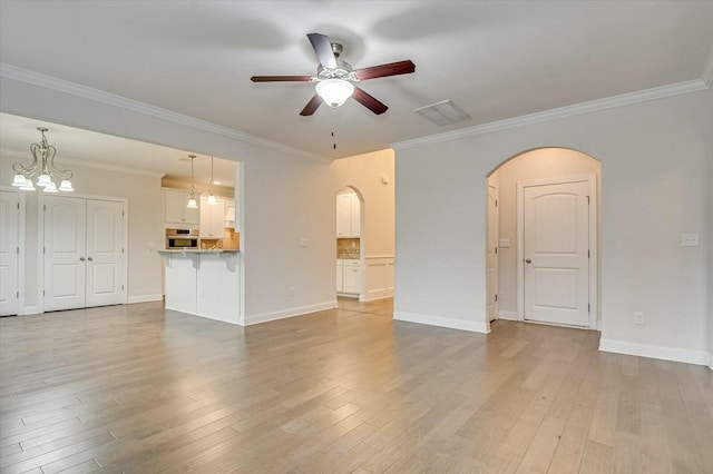 unfurnished living room with ceiling fan with notable chandelier, ornamental molding, and light hardwood / wood-style floors