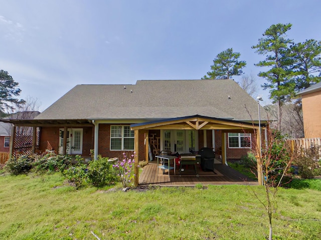 back of property featuring a deck, a yard, fence, and brick siding