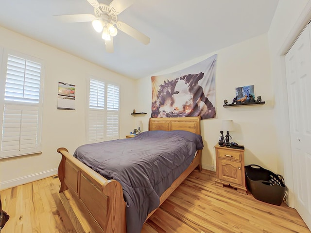 bedroom with a ceiling fan, light wood-type flooring, and baseboards