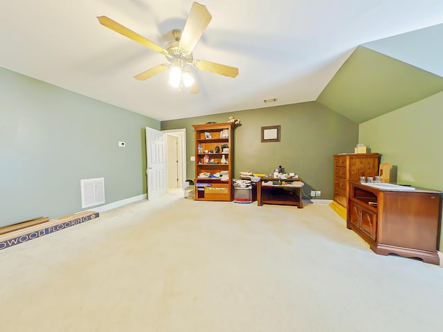 interior space featuring light carpet, visible vents, ceiling fan, and vaulted ceiling