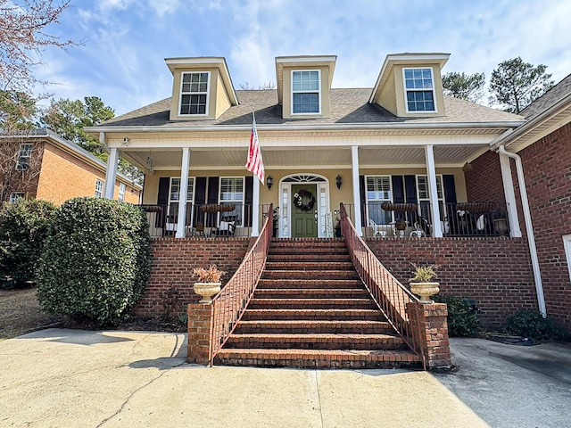 view of front facade featuring stairway and covered porch