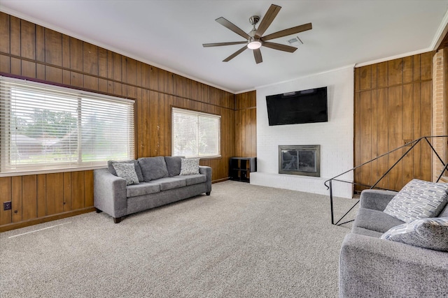 3414 Forest Estates Dr, Augusta, GA 30909 - living area featuring ornamental molding, wooden walls, ceiling fan, carpet, and a large fireplace