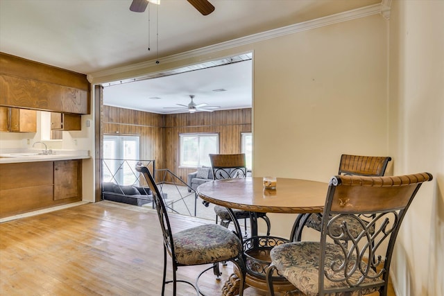 3414 Forest Estates Dr, Augusta, GA 30909 - dining space featuring ceiling fan, ornamental molding, light wood finished floors, and wood walls