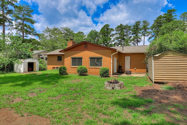 3414 Forest Estates Dr, Augusta, GA 30909 - back of house with a storage unit, a fire pit, a yard, a chimney, and brick siding