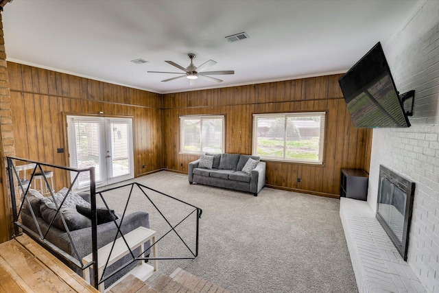 3414 Forest Estates Dr, Augusta, GA 30909 - living area featuring healthy amount of natural light, a ceiling fan, a brick fireplace, ornamental molding, and wood walls