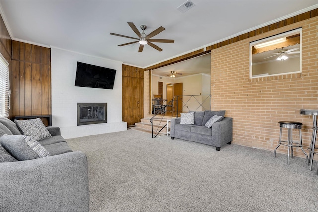 3414 Forest Estates Dr, Augusta, GA 30909 - carpeted living area with ceiling fan, ornamental molding, a glass covered fireplace, stairway, and wood walls