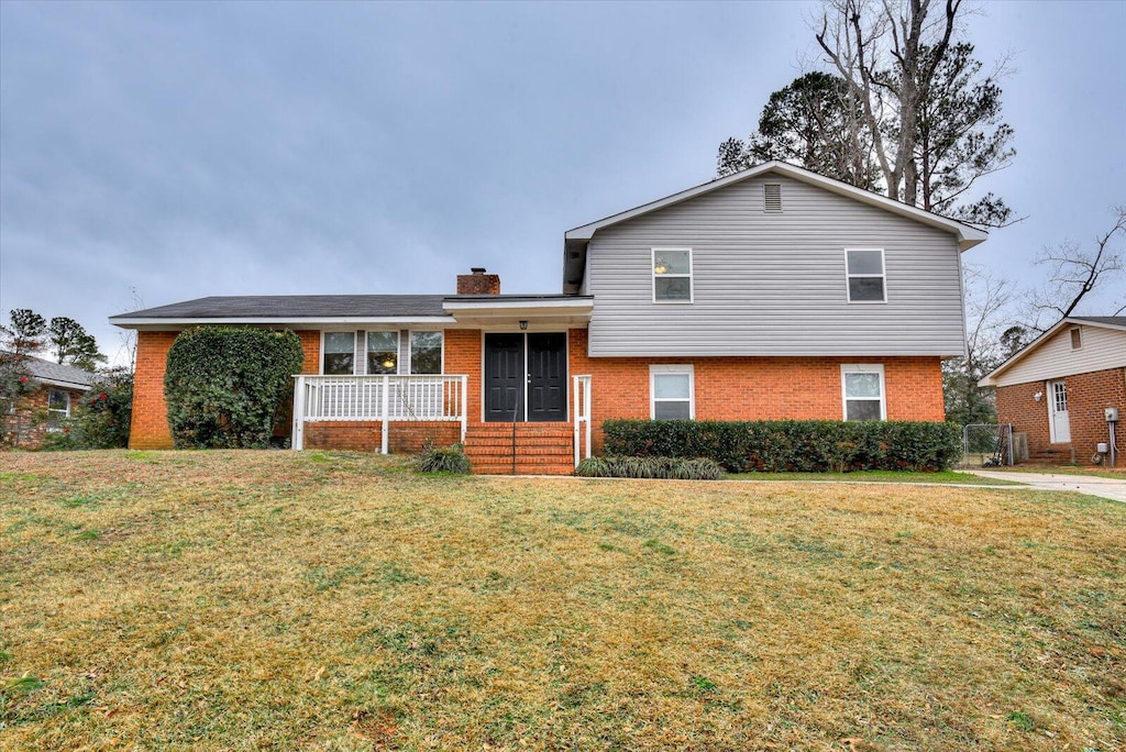 split level home with a front yard and a porch