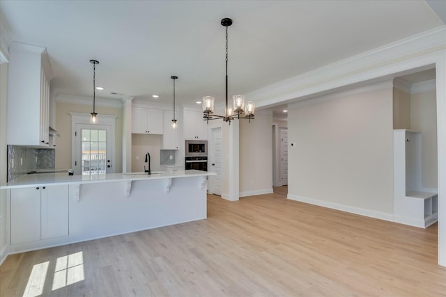 kitchen featuring stainless steel microwave, crown molding, oven, recessed lighting, and a peninsula