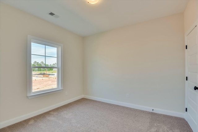 carpeted spare room featuring visible vents and baseboards