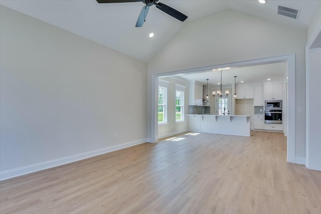 unfurnished living room featuring recessed lighting, high vaulted ceiling, visible vents, light wood-style flooring, and ceiling fan with notable chandelier