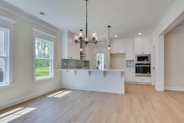 kitchen featuring ornamental molding, white cabinets, backsplash, and oven