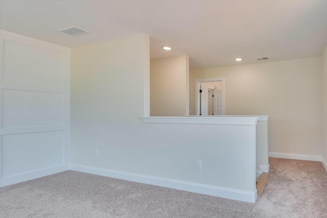 unfurnished room with visible vents, baseboards, and light carpet