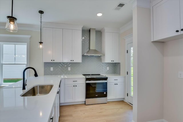 kitchen with a sink, stainless steel electric range oven, tasteful backsplash, visible vents, and wall chimney range hood