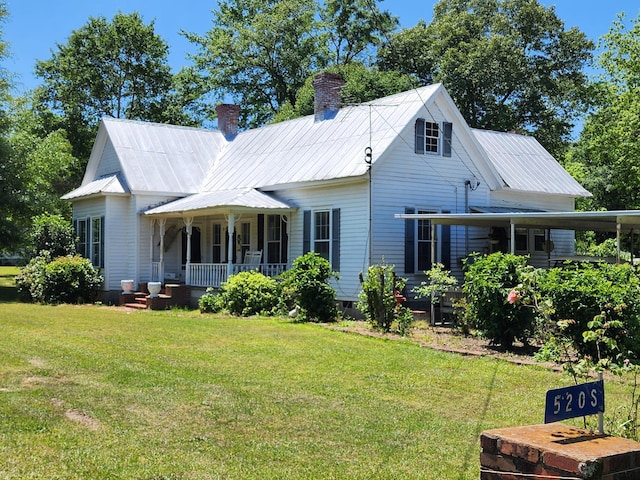 rear view of house featuring a porch and a lawn