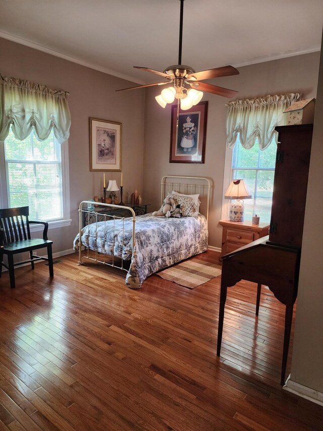 bedroom with ceiling fan, crown molding, and wood-type flooring